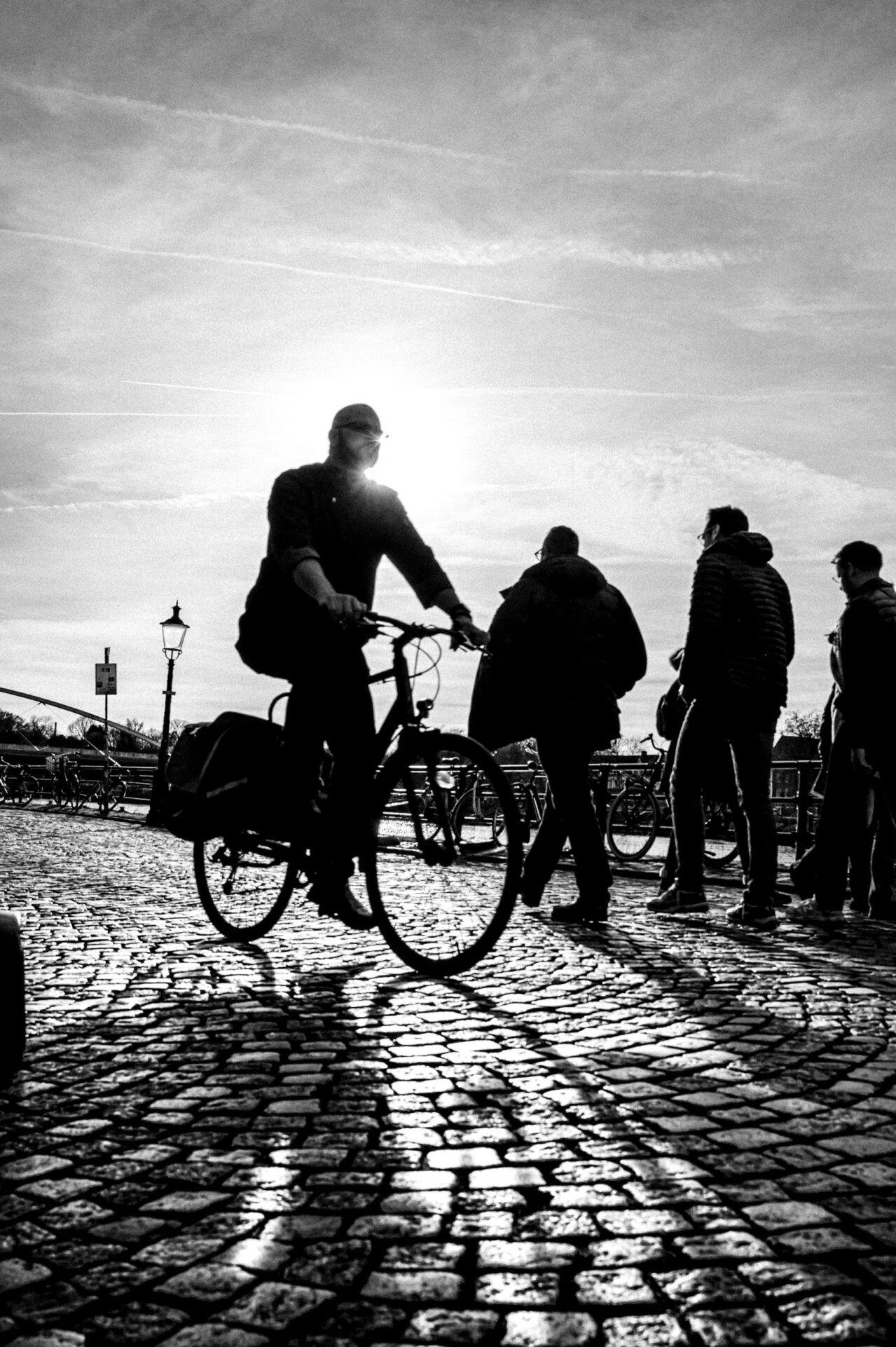 Foto met tegenlicht - silhouette fietser - Maastricht straatbeeld - aan de Maas - oude lantaarnpaal - karaktervol Nederland
