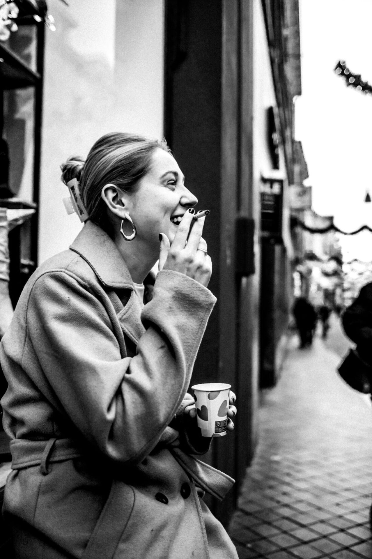 Straatfotograaf van Fotografie Focus maakt straatportretten - vrouw met koffie in haar hand en sigaret in haar mond