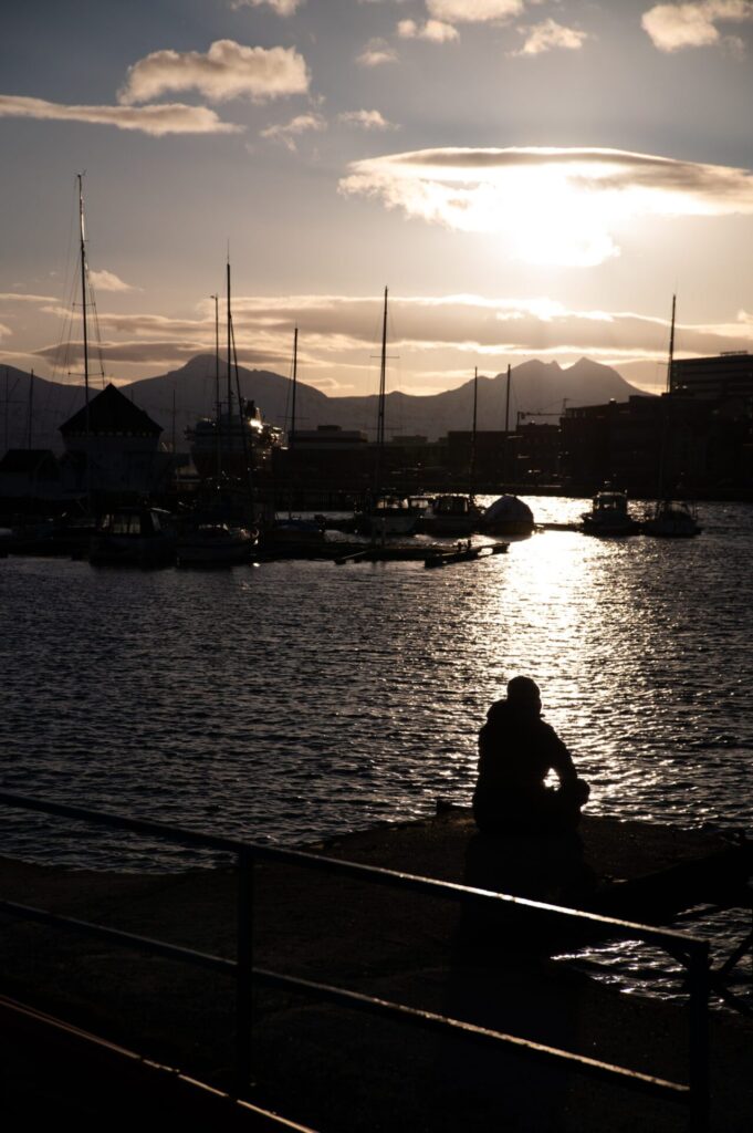 Noorwegen - Zonsondergang in de haven van Tromso - man mijment over het leven